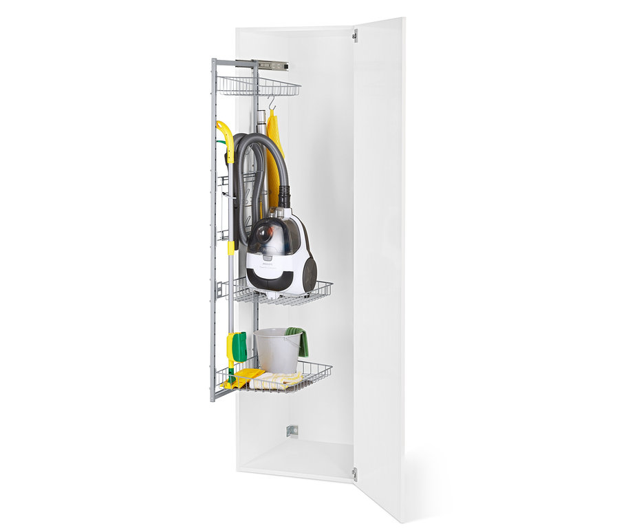 À l'intérieur d'une armoire blanche ouverte se trouve un système de rangement en fil métallique avec un aspirateur, une serpillière et des produits de nettoyage.