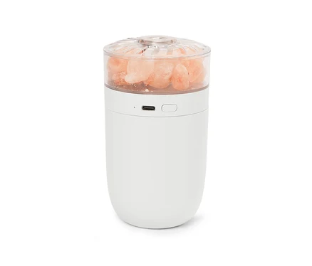 Lampe blanche avec des cristaux de sel roses dans un dessus transparent.