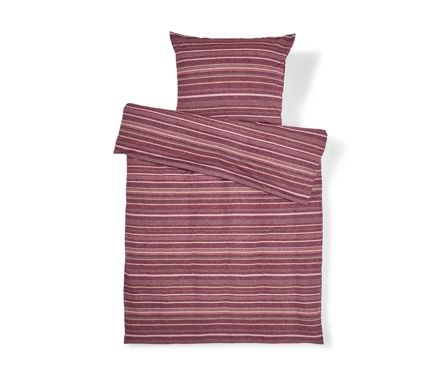Parure de lit rayée dans les tons de rouge et de rose, composée d'une taie d'oreiller et d'une housse de couette pliée.