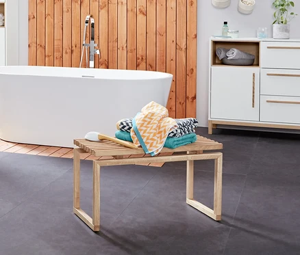 Intérieur de salle de bain avec un chariot d’appoint pour salle de bains «Eklund», buffet de salle de bains «Eklund», armoire haute pour salle de bains «Eklund» et linge de bain en jacquard.