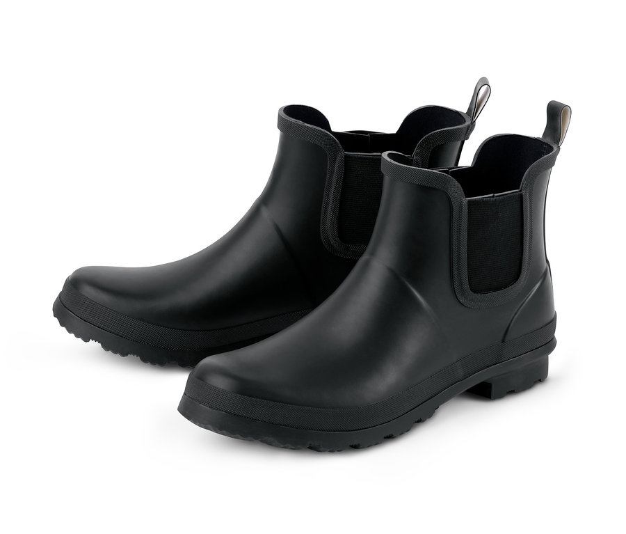 Deux bottines chelsea en caoutchouc noires sur fond blanc.