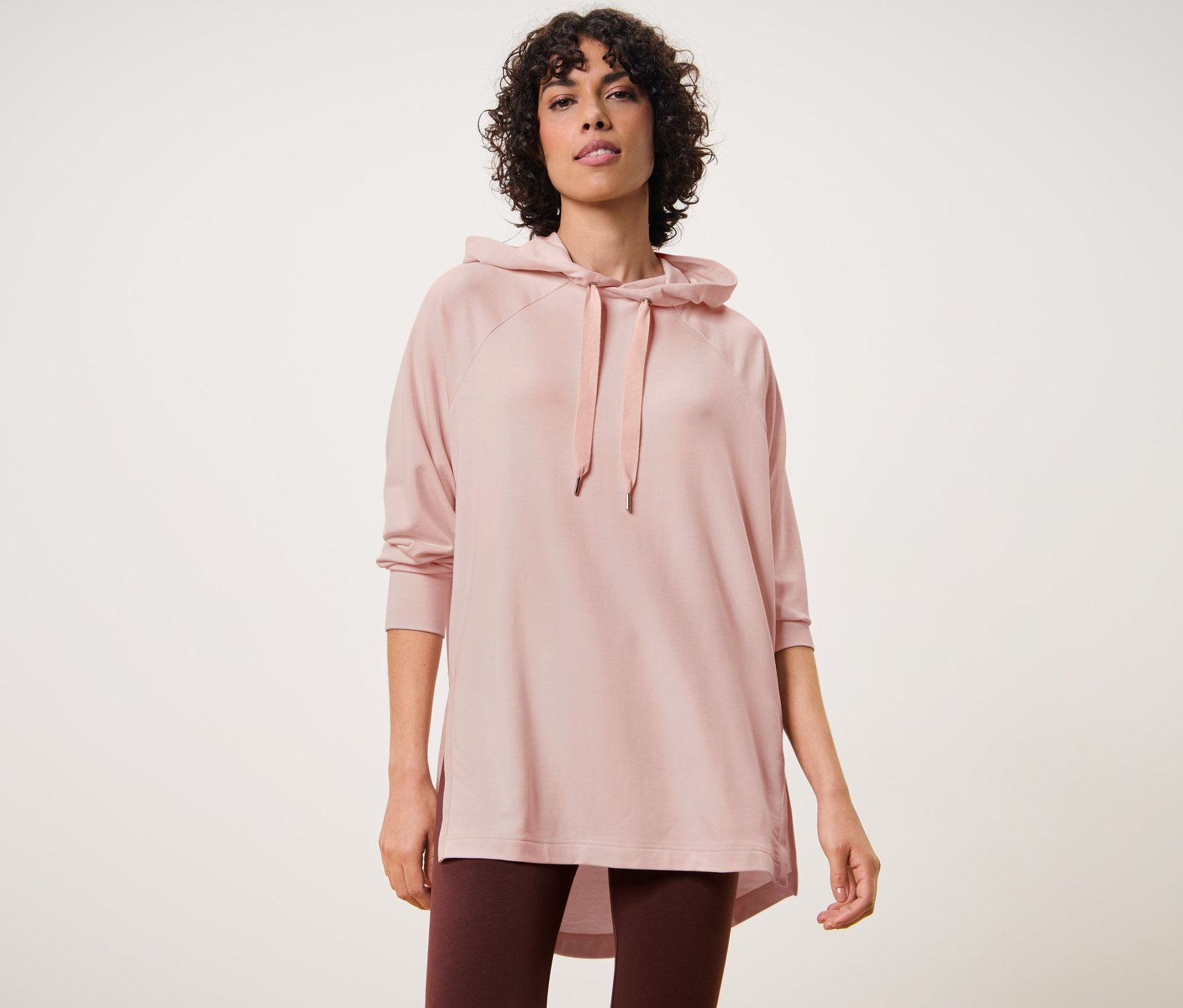 Femme portant un pull à capuche d'intérieur et des leggings.