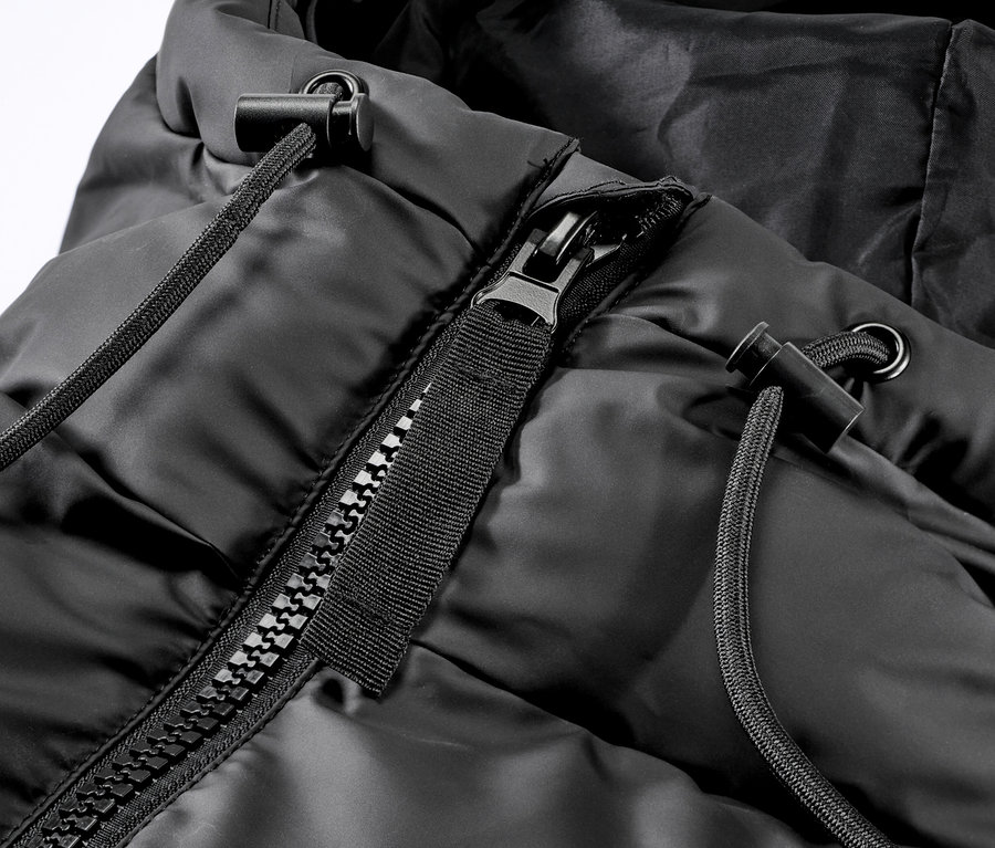 Gros plan sur un imperméable d’hiver noir avec capuche, fermeture éclair et cordon de serrage.