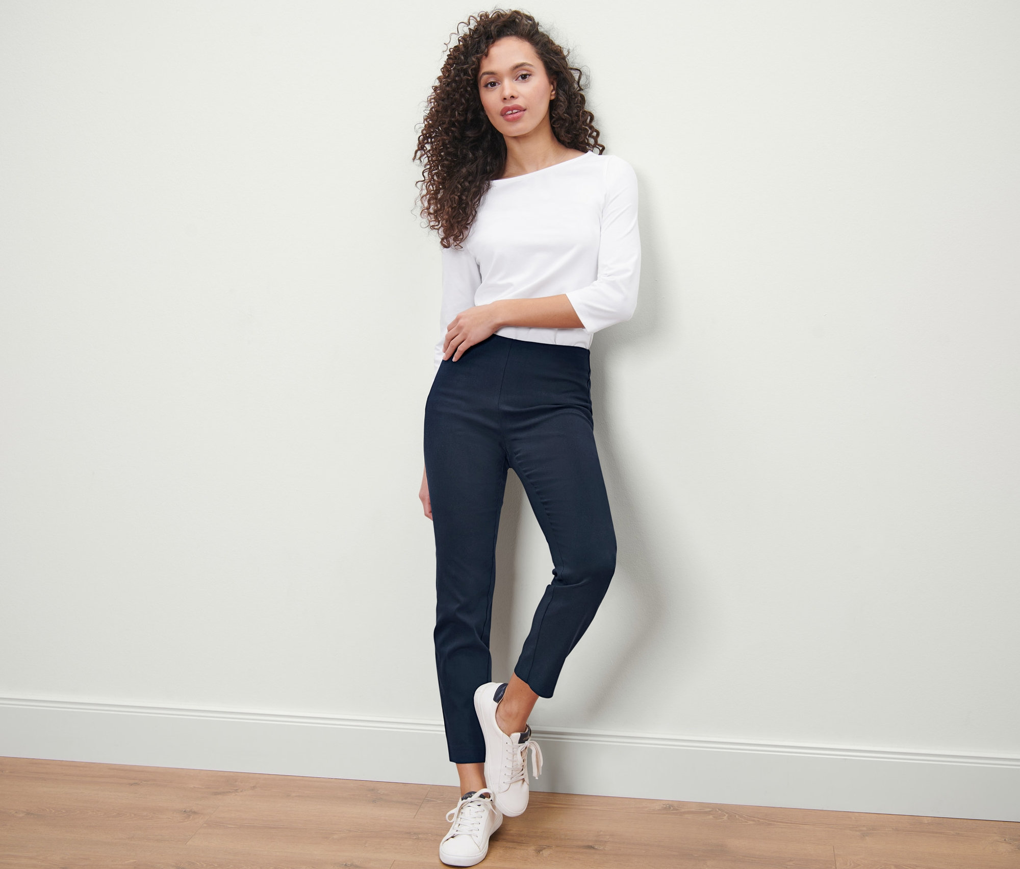 Femme posant en pantalon stretch bleu foncé.