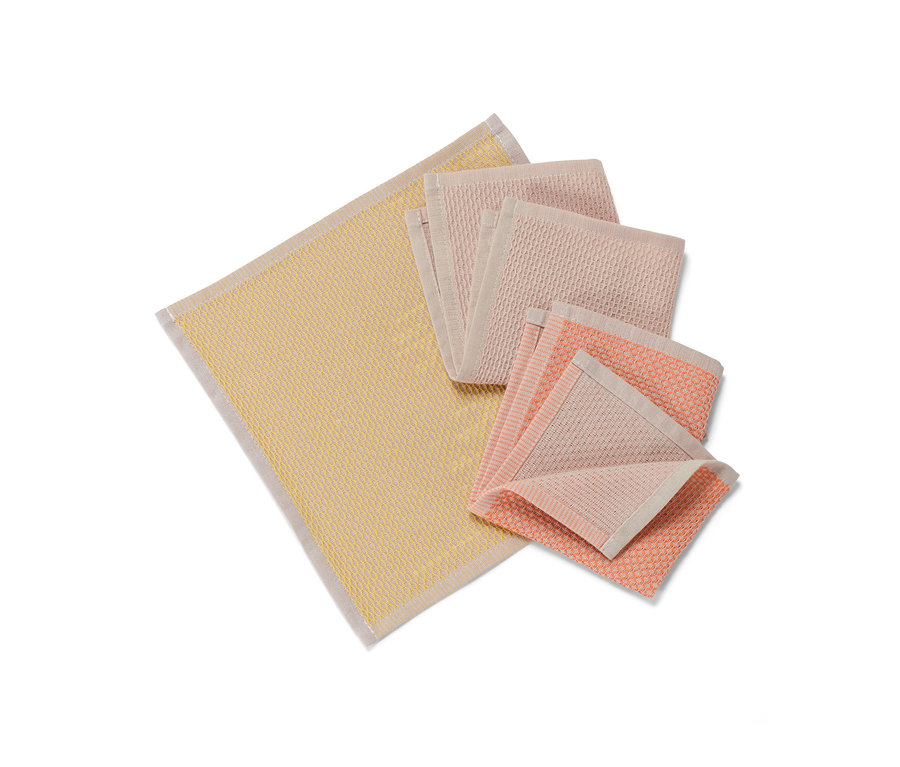 Des 3 lavettes jaunes et roses sont posées sur une surface blanche.