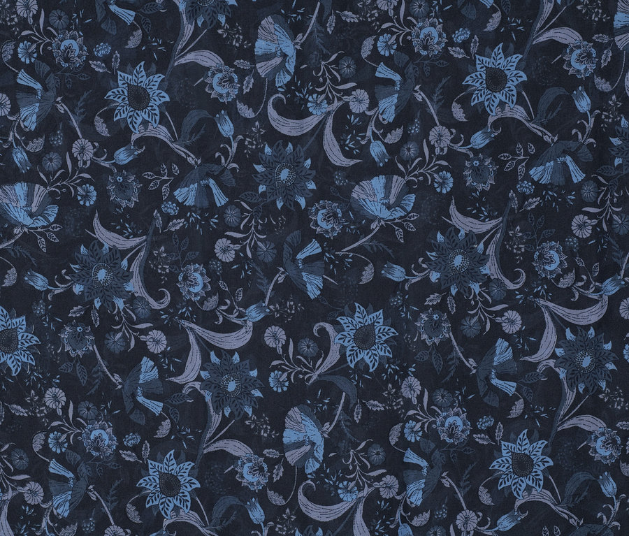 Gros plan d'un foulard loop imprimé avec un motif floral dans des tons de bleu sur un fond sombre.