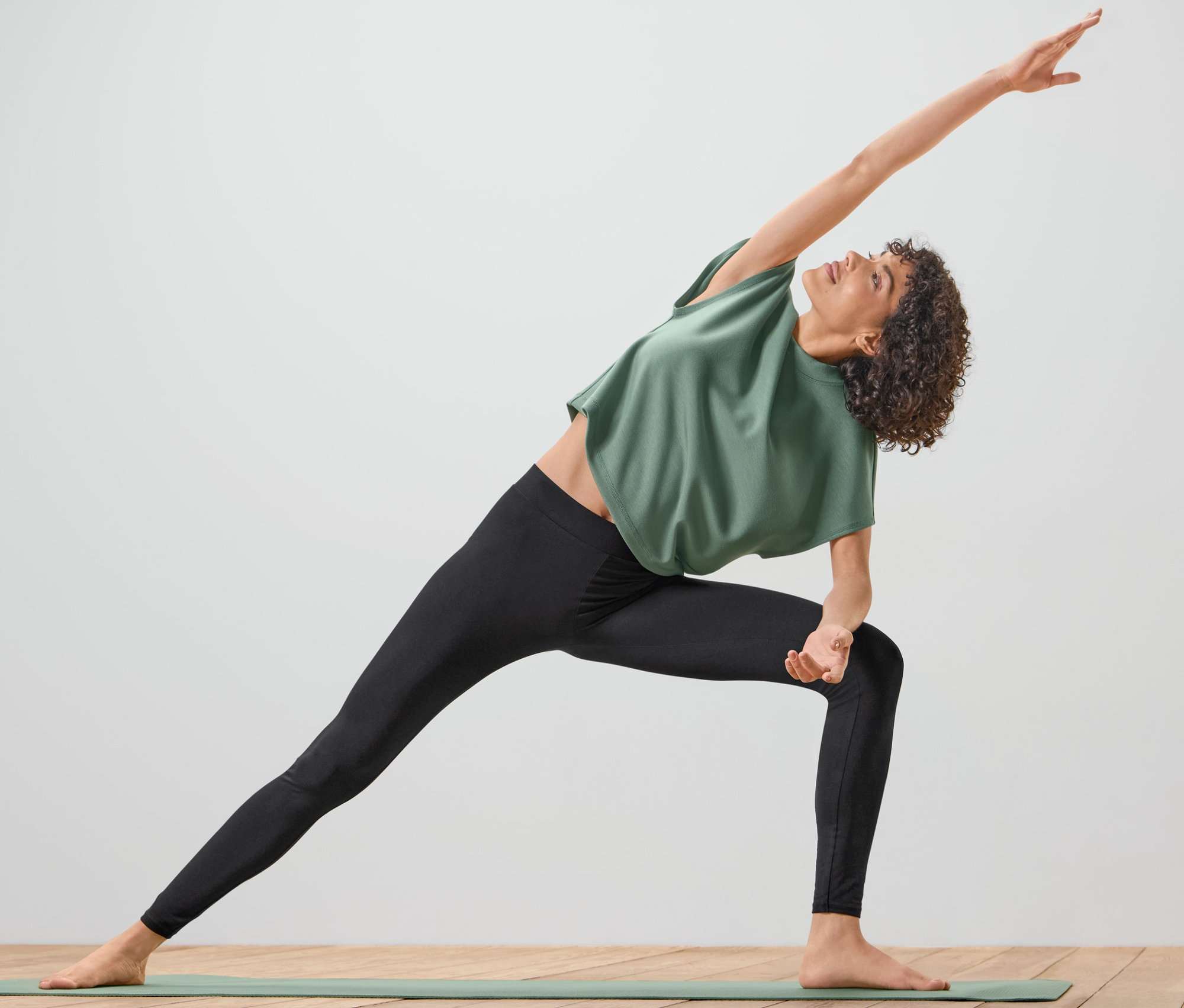 Femme faisant du yoga en portant un collant de sport noir.