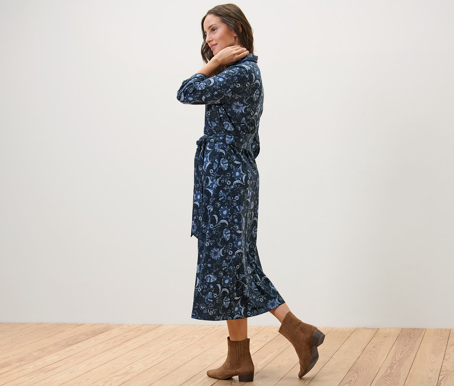 Femme posant de profil en robe en jersey imprimée et bottines marron.