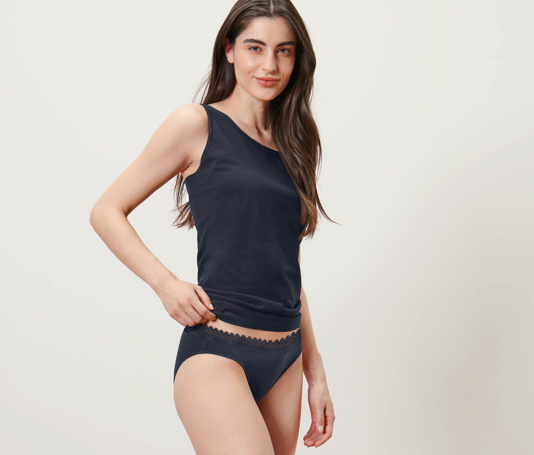 Femme posant en débardeur et 2 slips, bleu foncé.