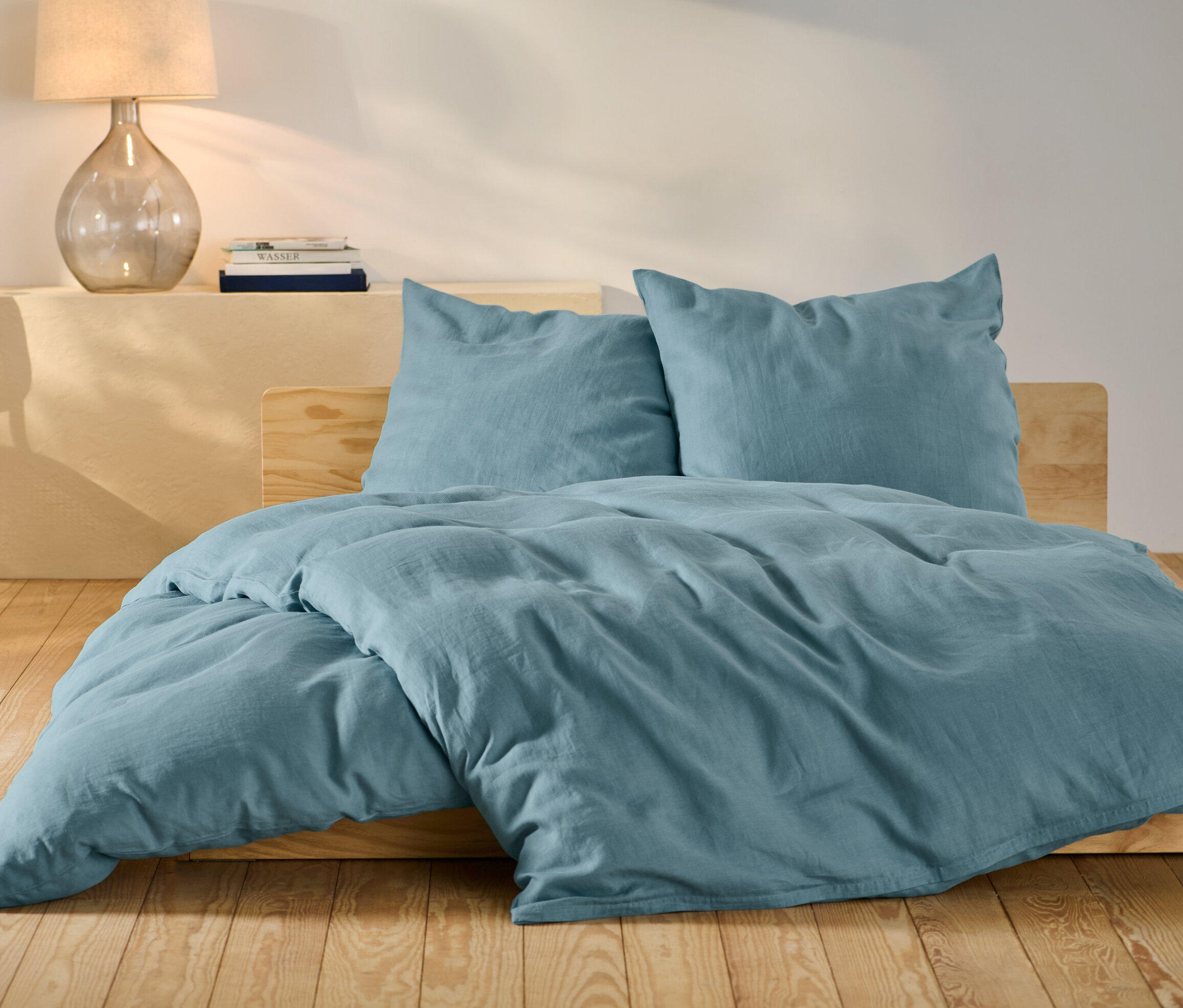 Parure de lit en lin bleu de taille standard et grande taille sur un lit.