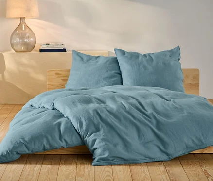 Parure de lit en lin bleu de taille standard et grande taille sur un lit.