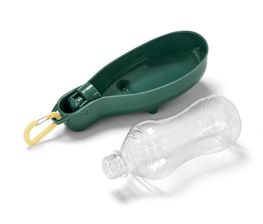 Une gourde pour chien avec gamelle intégrée est posée à côté d'une bouteille en plastique transparent.