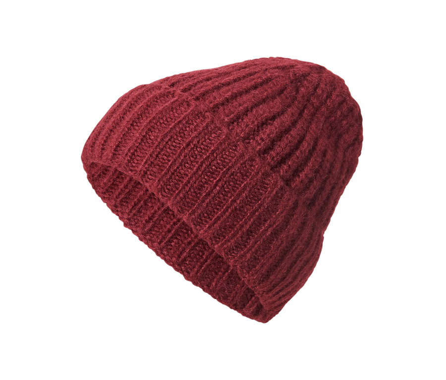 Un bonnet en maille avec de la laine sur fond blanc.