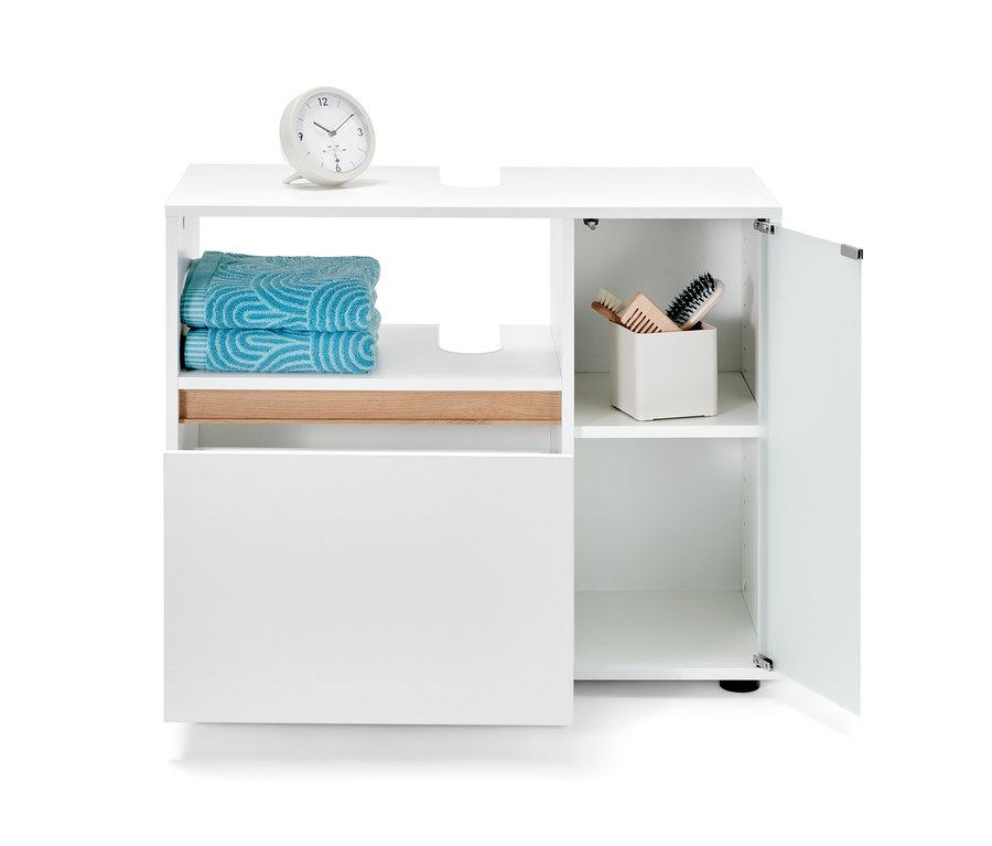 Meuble sous vasque de salle de bain blanc avec serviettes et produits cosmétiques.