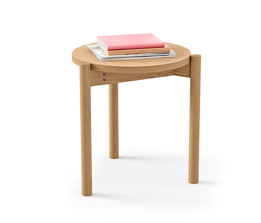 Une table d'appoint ronde en bois avec trois livres dessus.