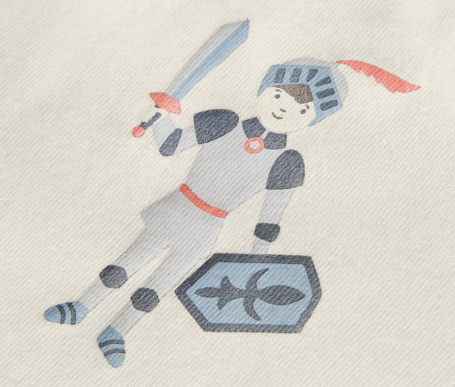 Sur le body bébé figure un dessin de chevalier avec une épée et un bouclier.