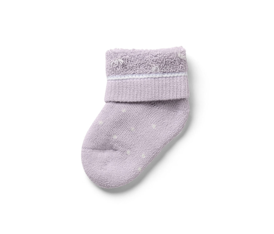Gros plan d'une seule chaussette de bébé violette avec des points blancs. 7 paires de chaussettes pour bébé, cygne.