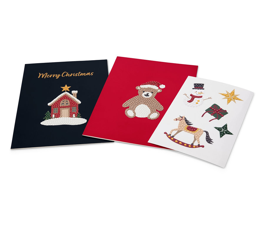 Trois cartes de Noël : bleu marine avec une maison et « Joyeux Noël », rouge avec un ours en peluche et blanche avec un cheval à bascule, un bonhomme de neige, un cadeau et des étoiles.