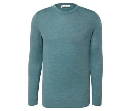 Un pull en laine mérinos bleu clair chiné est posé sur un fond blanc.