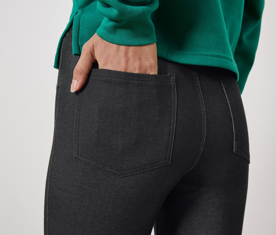 Gros plan sur un jegging noir pour femme avec une main dans la poche.
