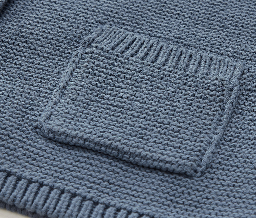 Détail d'une poche tricotée bleue.