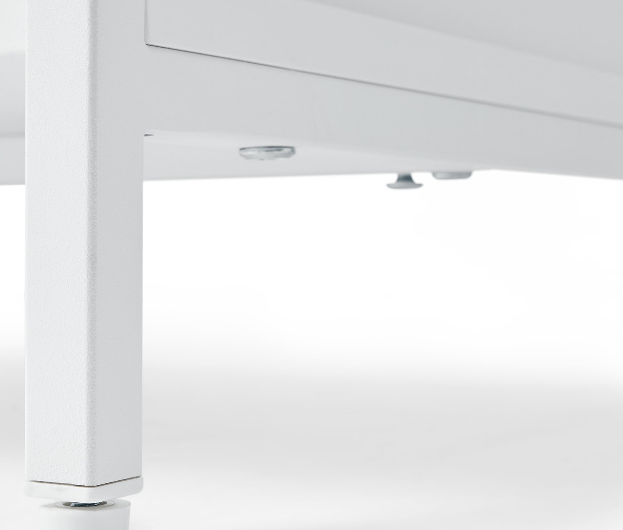 Gros plan sur une commode blanche »KLAAR« à 4 tiroirs, vue du dessous des pieds.