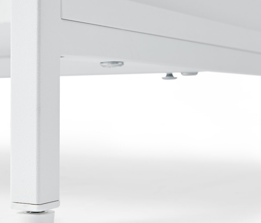 Gros plan sur une commode blanche »KLAAR« à 4 tiroirs, vue du dessous des pieds.
