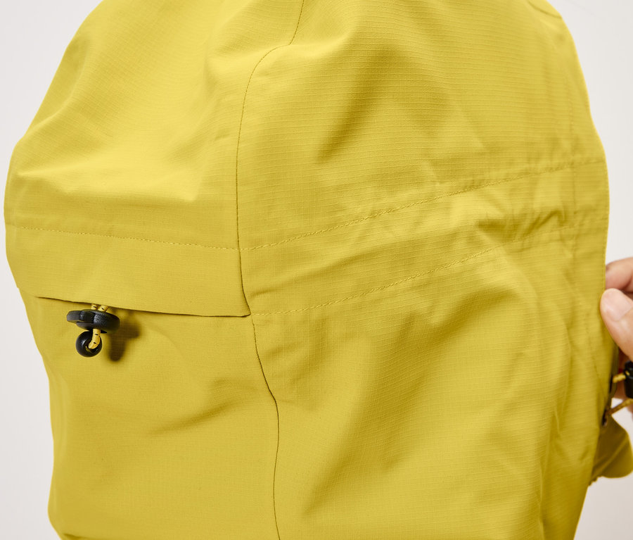 Gros plan sur la capuche d'une veste jaune avec cordon de serrage.
