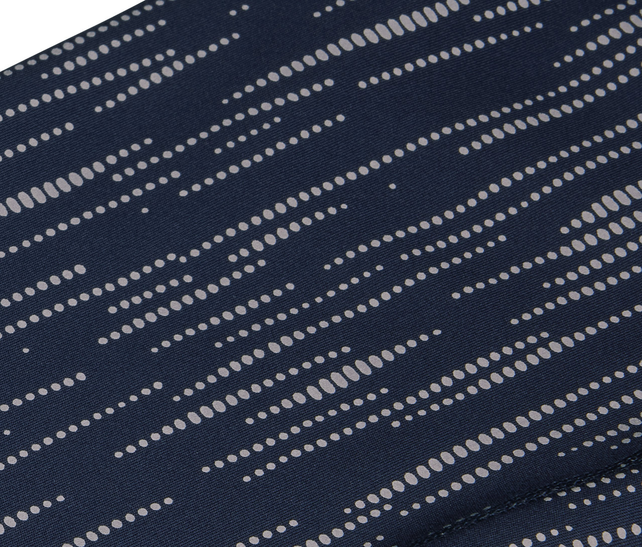 Gros plan d'un tissu bleu marine avec un motif de points blancs parallèles.