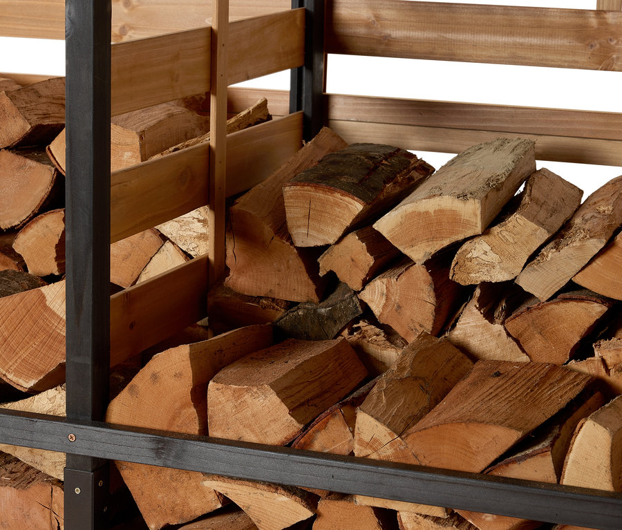 Bois stocké dans un abri à bois de chauffage avec paroi arrière.