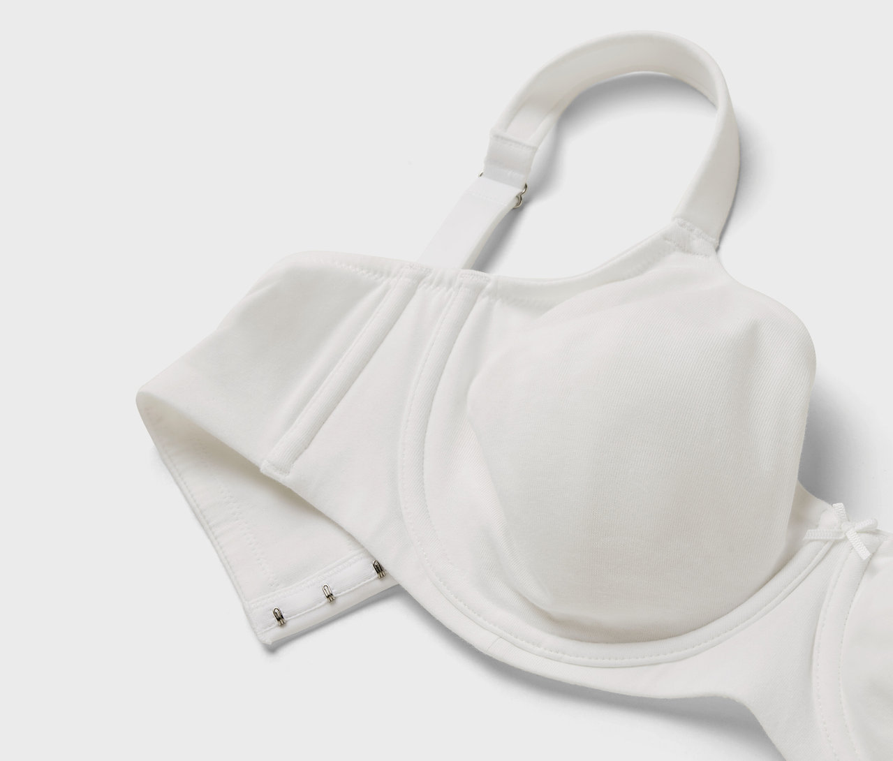 Gros plan d'un soutien-gorge blanc avec bretelles réglables et fermeture à agrafes.