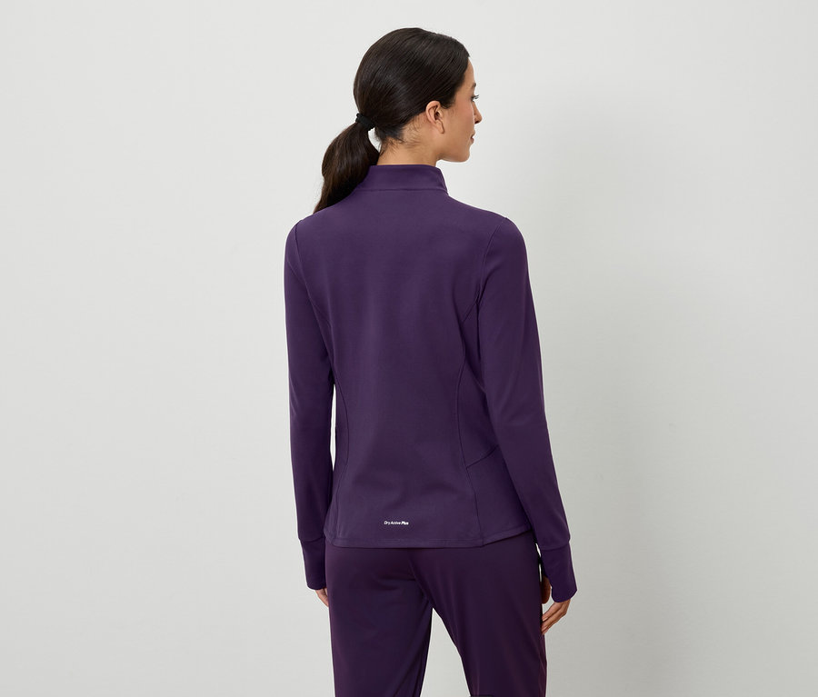 Vue arrière d'une femme aux cheveux bruns attachés en queue de cheval, portant une veste et un pantalon violets.