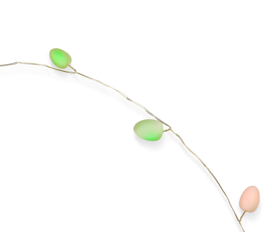 Guirlande lumineuse décorative avec trois œufs de Pâques pastel (vert, rose) sur fond blanc.