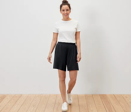 Une femme porte un short en jersey noir.