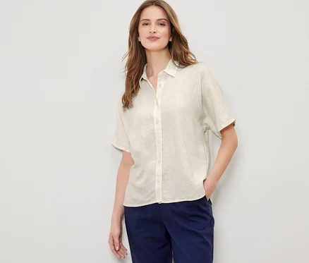 Femme posant en chemisier en lin blanc crème.