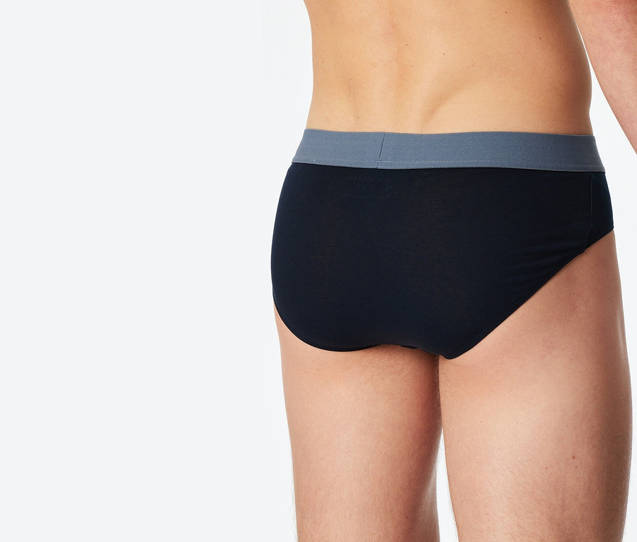 Gros plan de la vue arrière d'une personne portant un slip noir avec une ceinture grise.