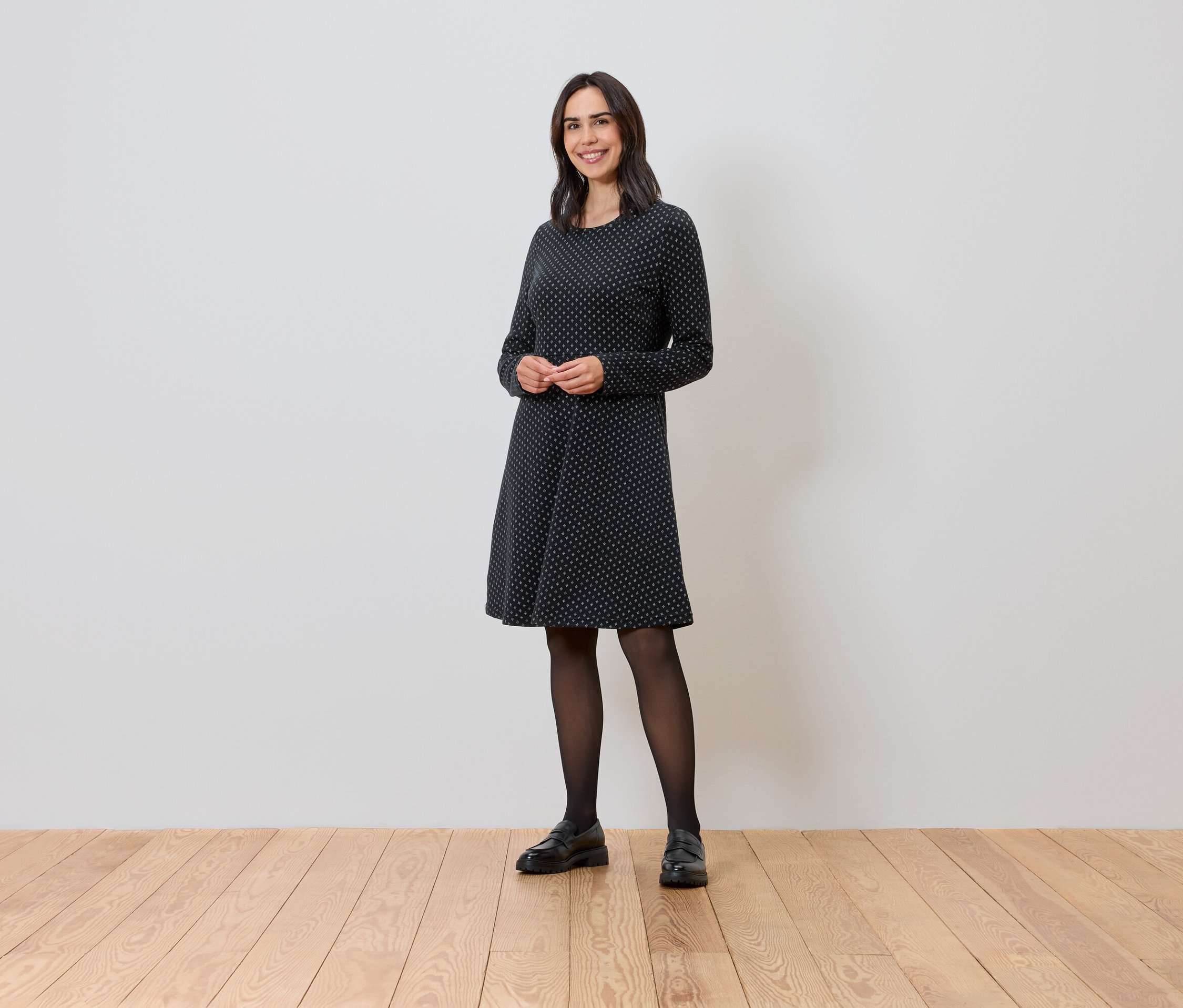 Femme debout portant une robe en jacquard scintillant.