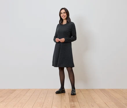Femme debout portant une robe en jacquard scintillant.