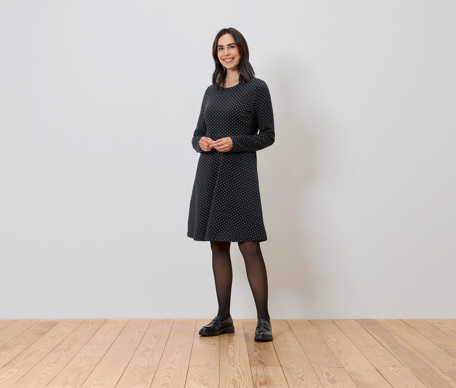 Femme debout portant une robe en jacquard scintillant.