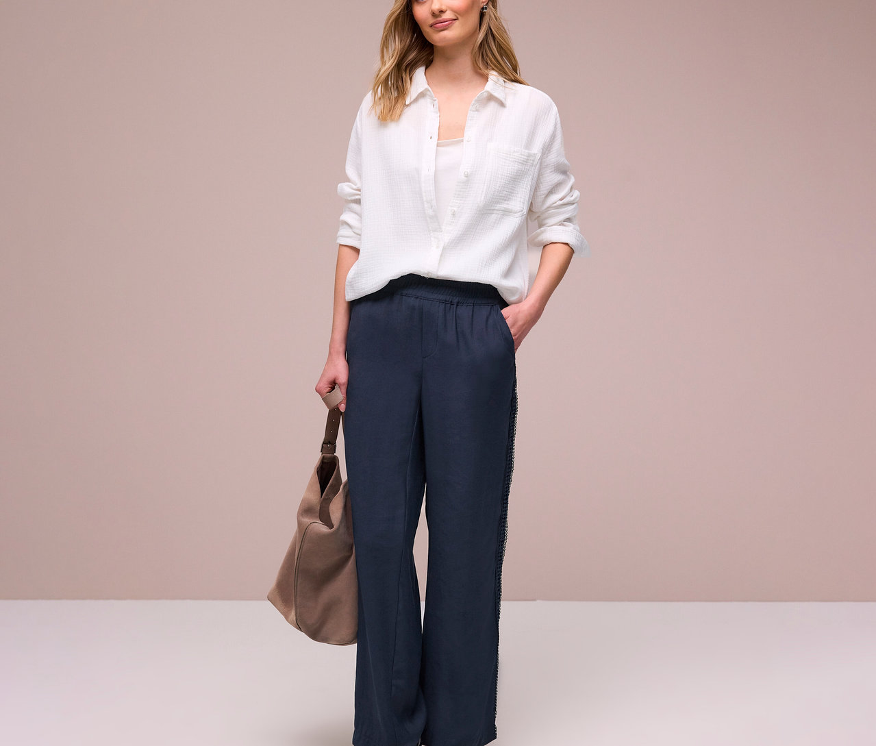 Femme en chemise blanche et pantalon Street One « Emee » avec sac beige et baskets.