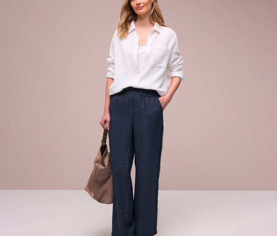 Femme en chemise blanche et pantalon Street One « Emee » avec sac beige et baskets.