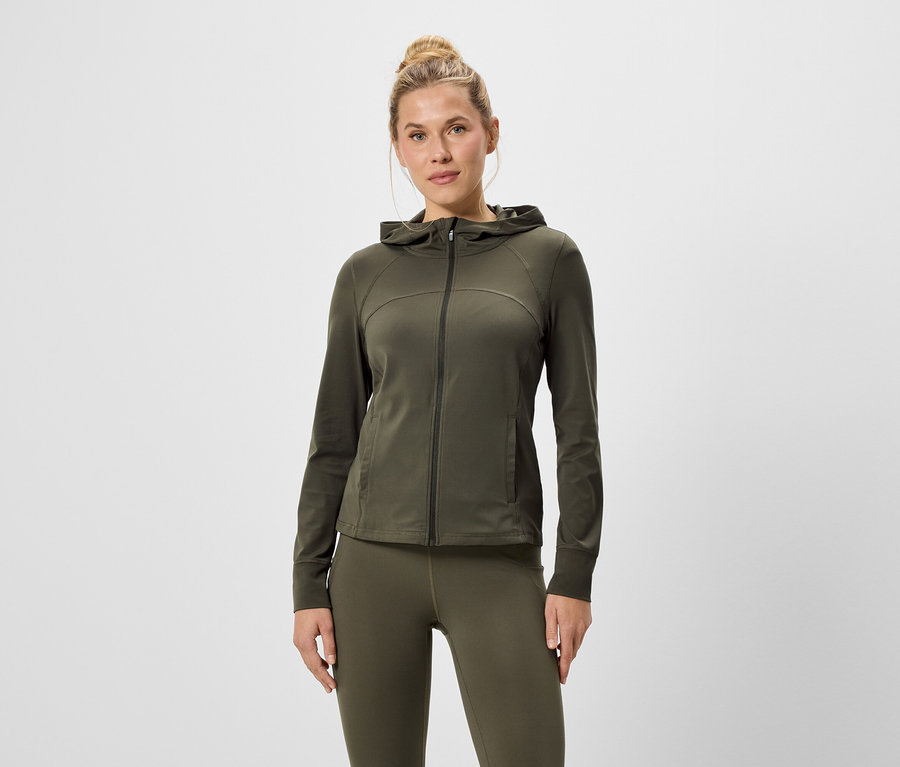 Femme portant un sweat à capuche zippé vert olive et un legging.