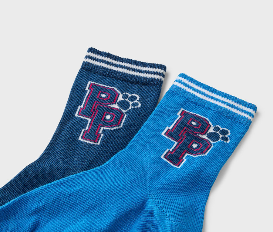 Gros plan de deux chaussettes : une bleu marine et une bleue, toutes deux avec un motif à rayures blanches sur le dessus et un logo « P » rouge avec une empreinte de patte.
