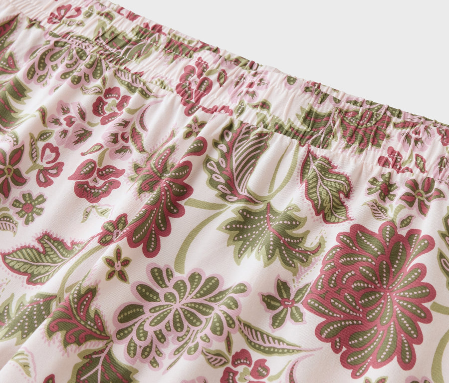 Gros plan sur un tissu à motifs floraux dans les tons rose, vert et rouge.