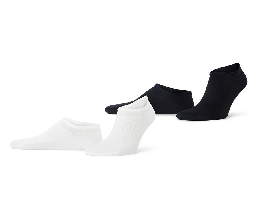 Deux paires de socquettes de sport extra-fines noires et blanches posées sur un fond blanc.