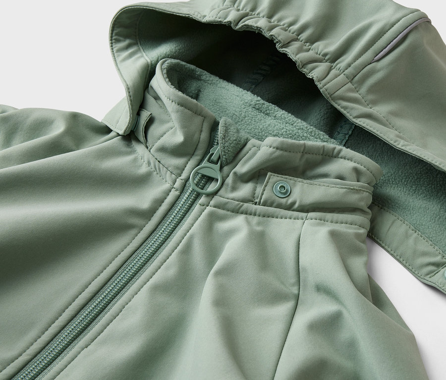 Gros plan d'une veste vert clair avec capuche, fermeture éclair et bouton-pression.