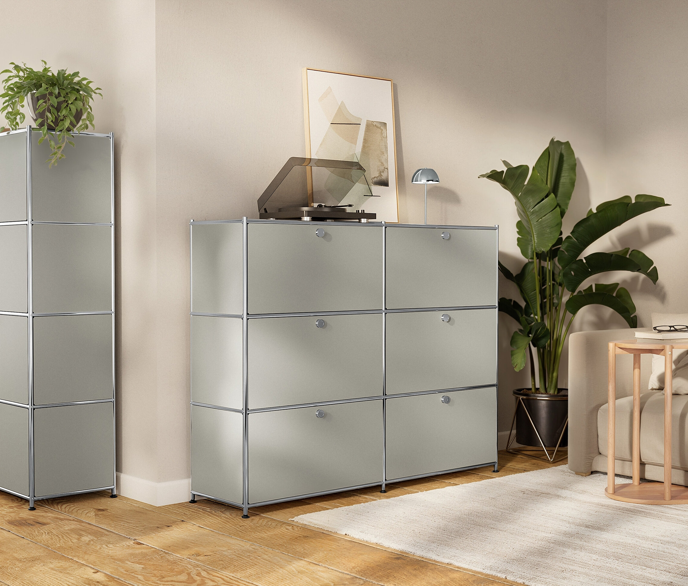 Salon avec des armoires de rangement modulaires grises, un tourne-disque, des plantes d'intérieur et un canapé.