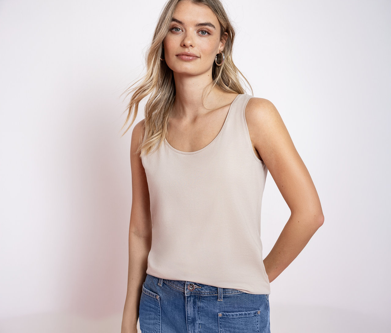 Une femme blonde porte un haut classique Street One et un jean.