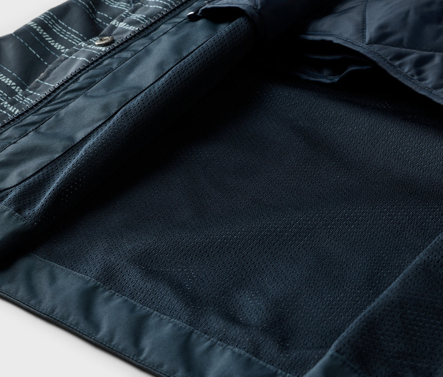 Vue intérieure d'une veste bleu marine ouverte avec une doublure en filet et un rembourrage matelassé.