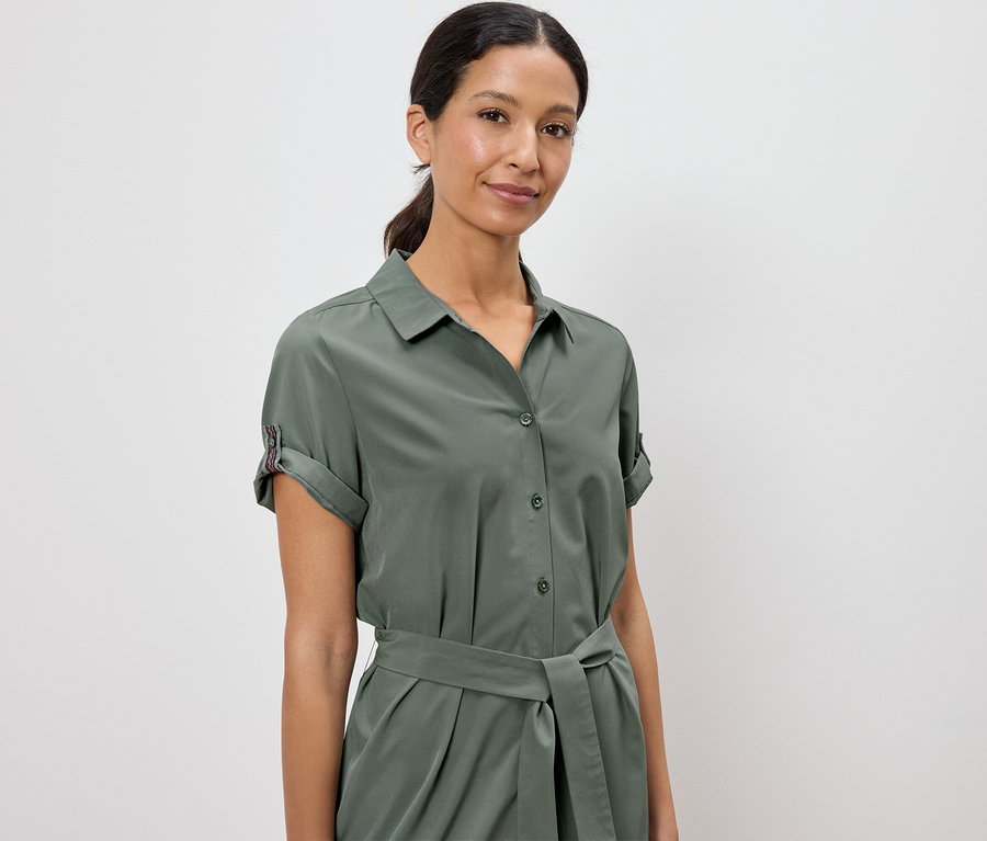 Femme portant une robe chemise vert olive avec ceinture.